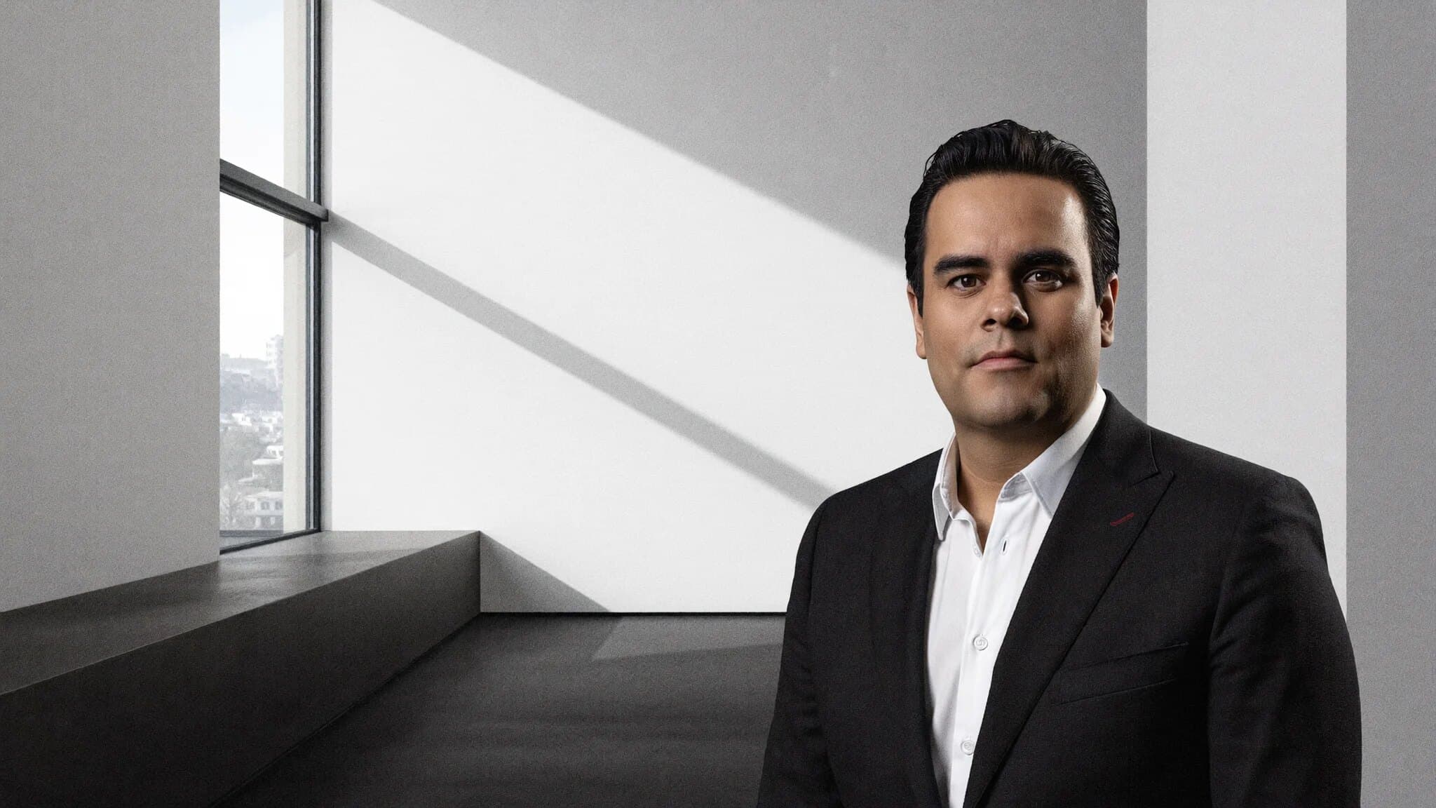 Edgard Vargas en su oficina, junto a una ventana con vista a la ciudad